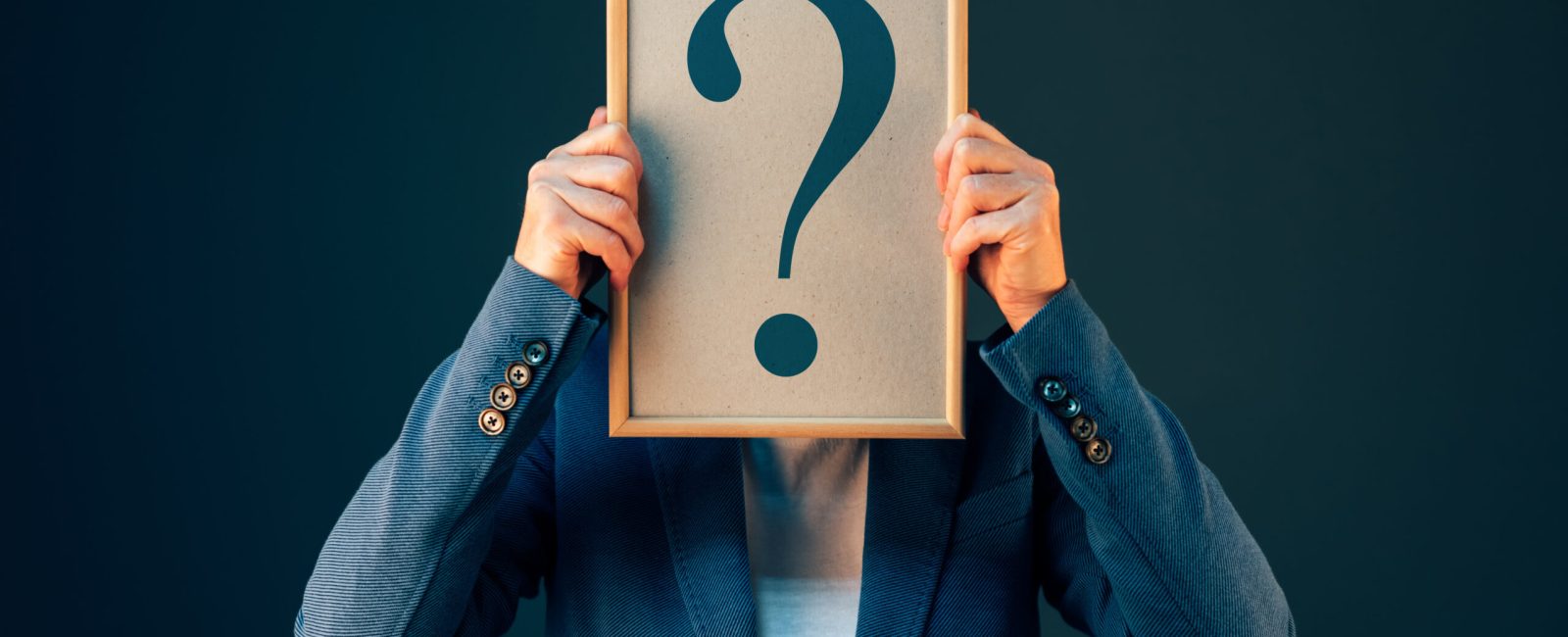 Businesswoman with question mark looking for answers, questioning and wondering about uncertain future in corporate business