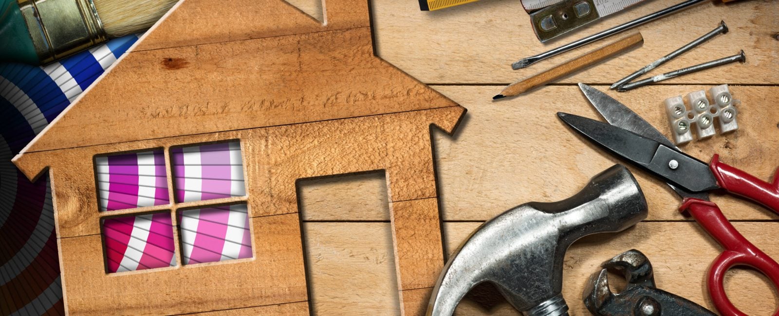 Home improvement concept - Wooden model house on a work table with tools