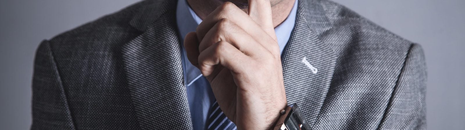 Caucasian man making silence gesture.
