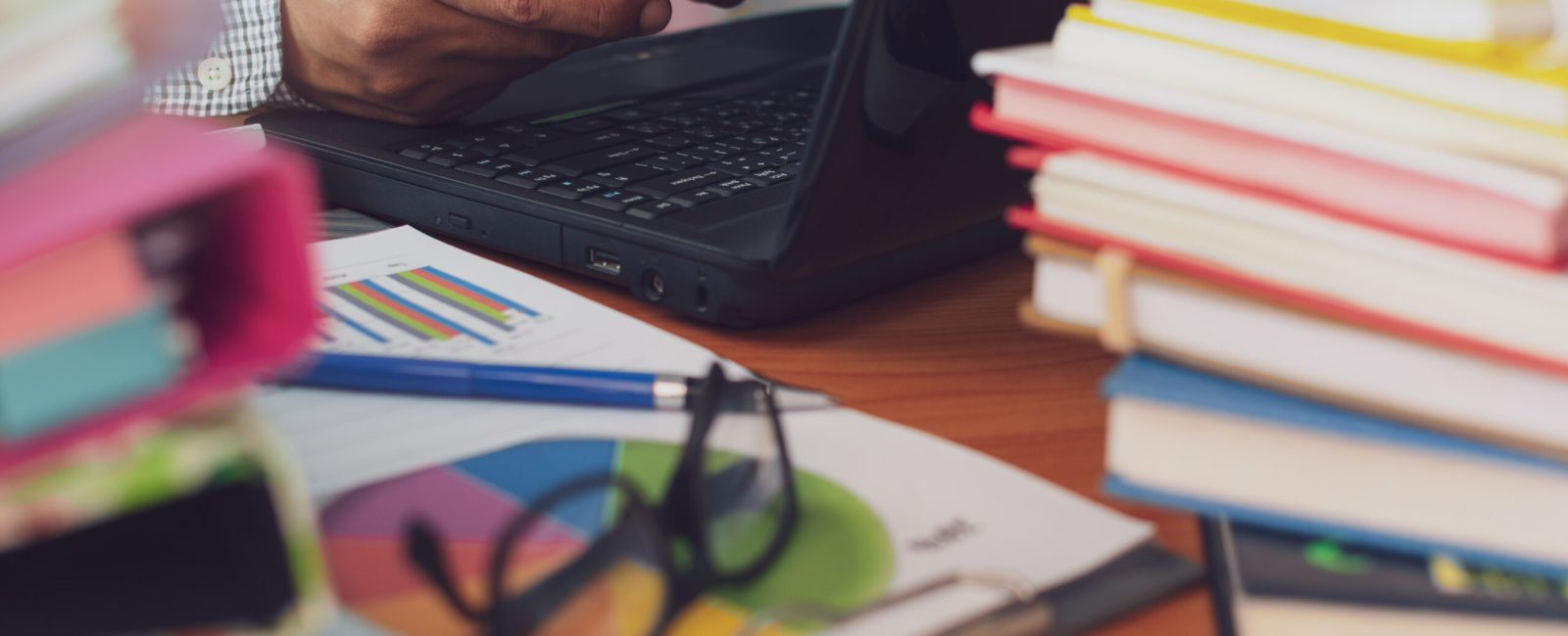 Man is using mobile phone and working with stack of documents on office desk, Businessman is analyzing marketing with statistics chart, Business and Office life concept.