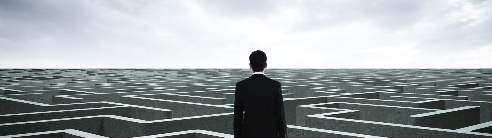 Businessman going straight ahead on a wide road between mazes