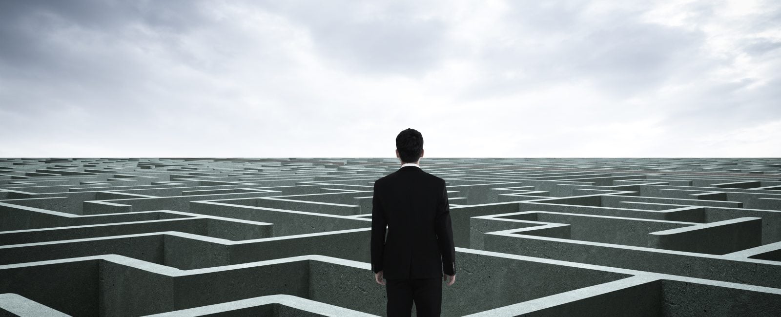 Businessman going straight ahead on a wide road between mazes