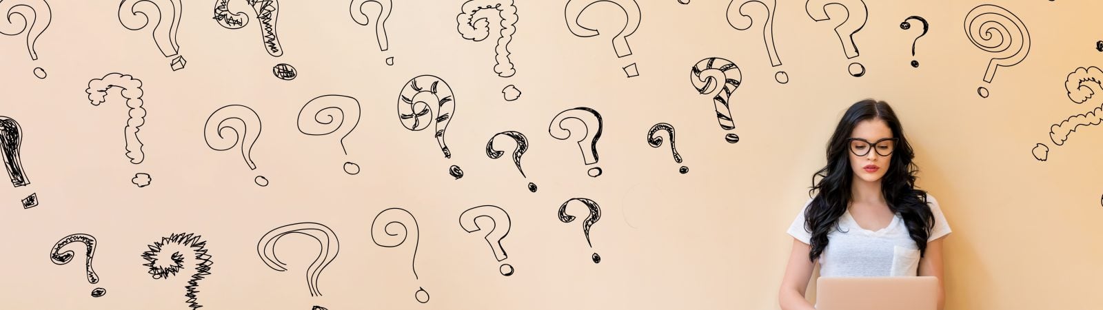 Small question marks with young woman using a laptop computer