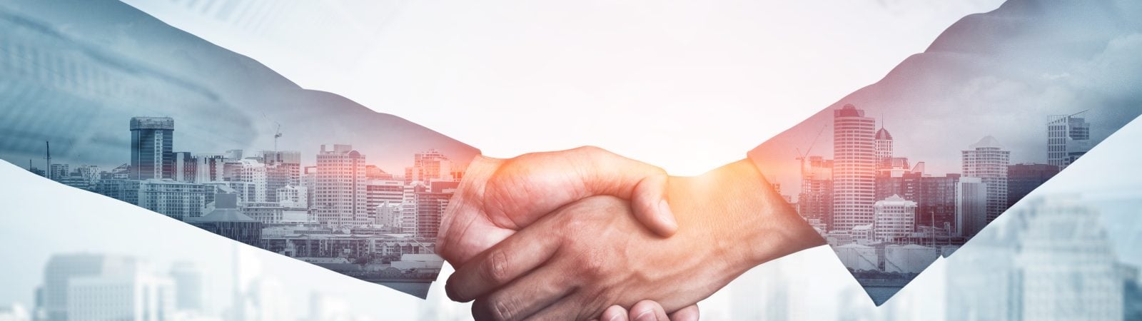 Double exposure image of business people handshake on city office building in background showing partnership success of business deal. Concept of corporate teamwork, trust partner and work agreement.