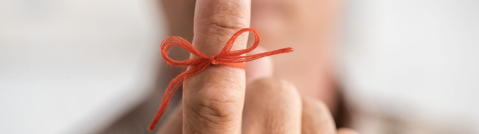 selective focus of red bow on finger of senior man with mental illness