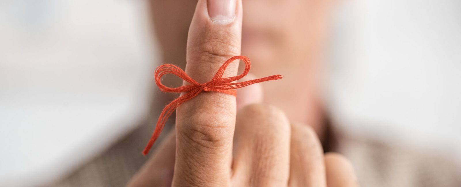 selective focus of red bow on finger of senior man with mental illness