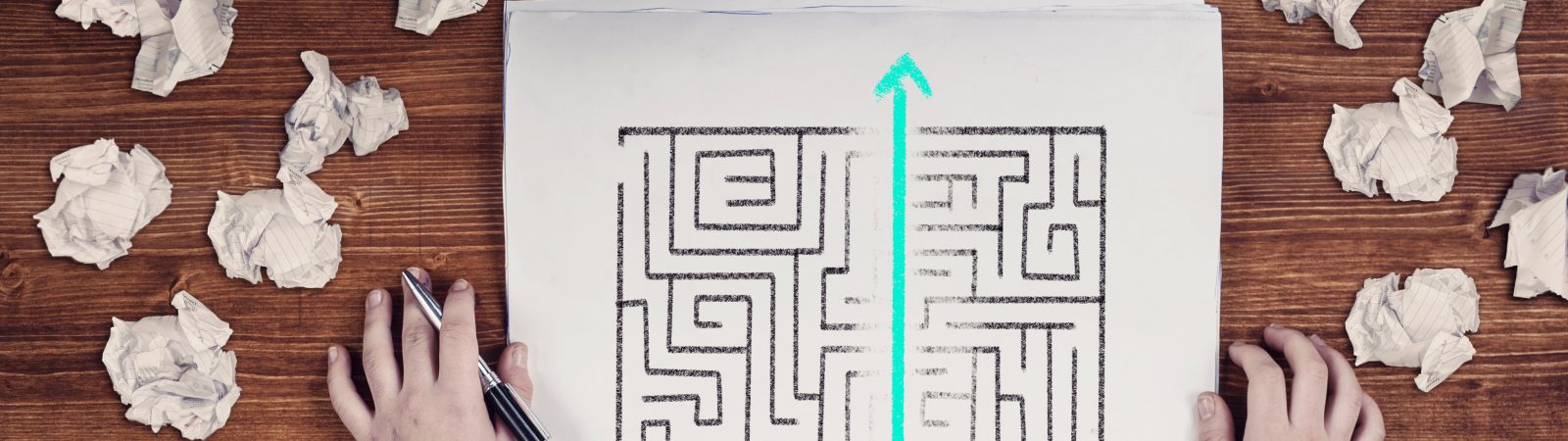 Shortcut of a maze drawn on paper . Crumpled papers arround. Easy solution of a difficult problem.