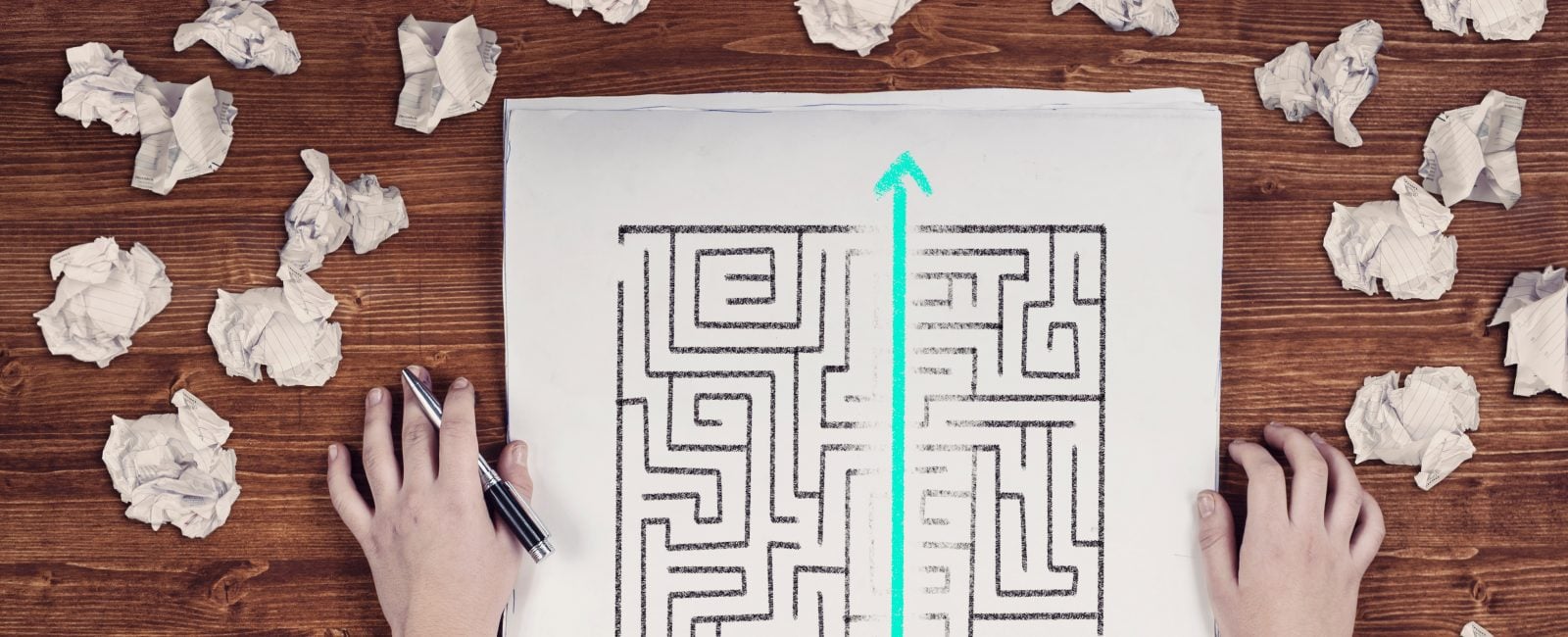 Shortcut of a maze drawn on paper . Crumpled papers arround. Easy solution of a difficult problem.