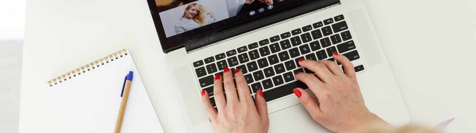 Cropped image of young female student attending online lecture on laptop at desk