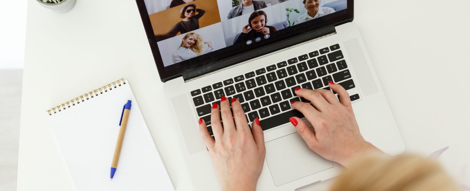Cropped image of young female student attending online lecture on laptop at desk