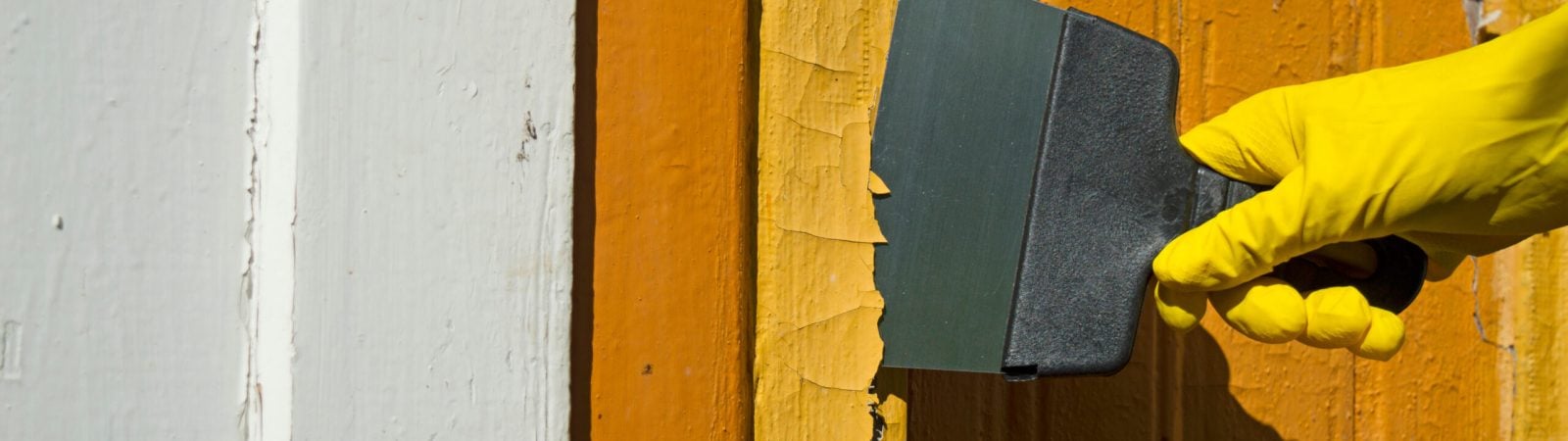 Cleaning the facade of paint with a sharp spatula. Coating removal with a construction tool. Repair in the household. Selective focus