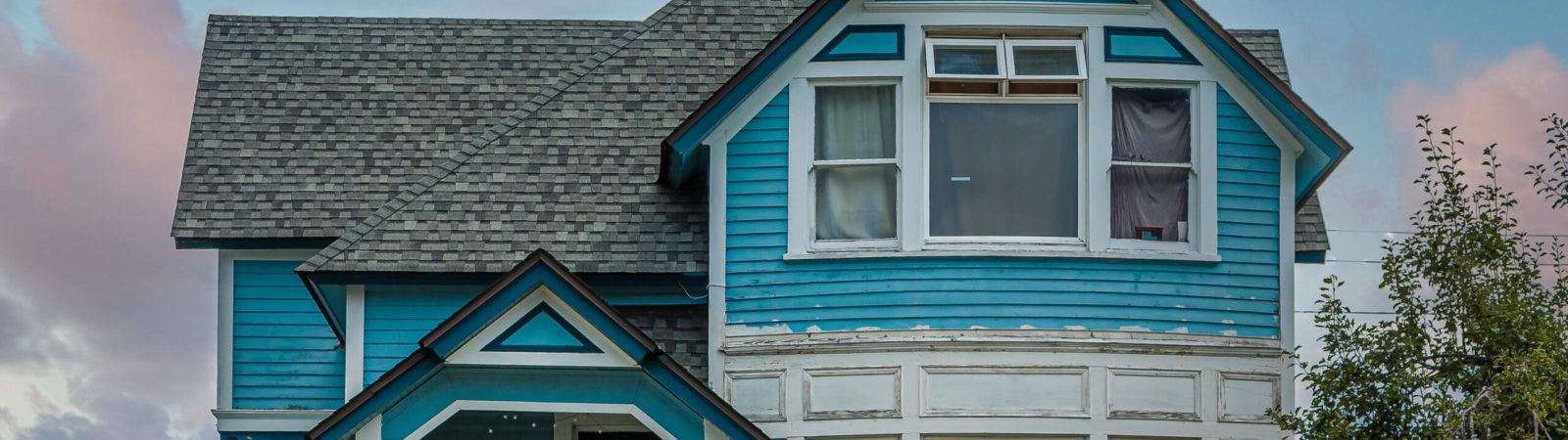 A Blue Victorian House on Hill