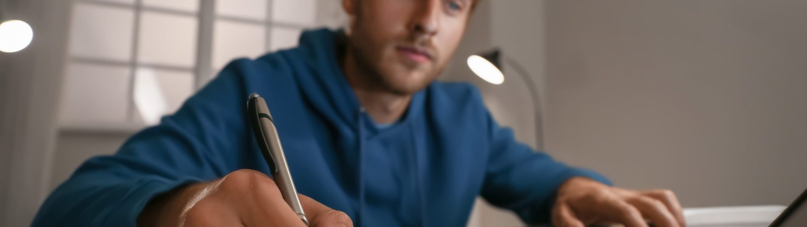 Young man using laptop for online learning at home