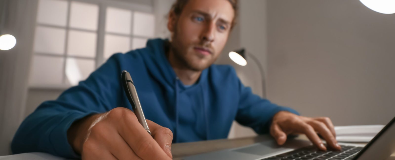 Young man using laptop for online learning at home