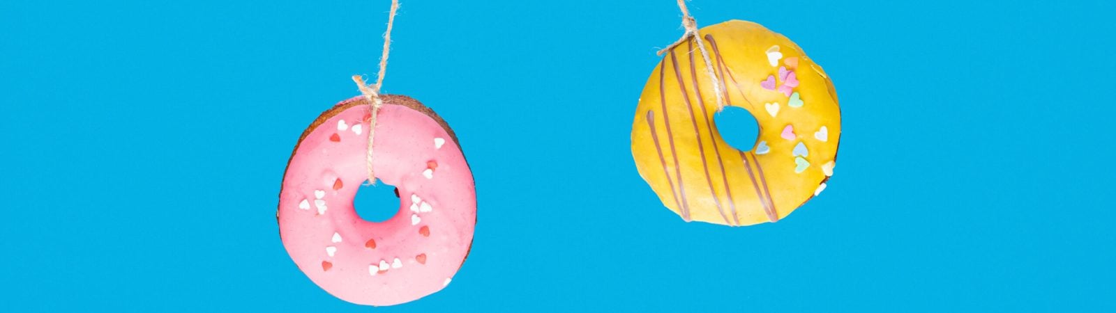 Momentum and time, collision concept with two donuts on blue background.