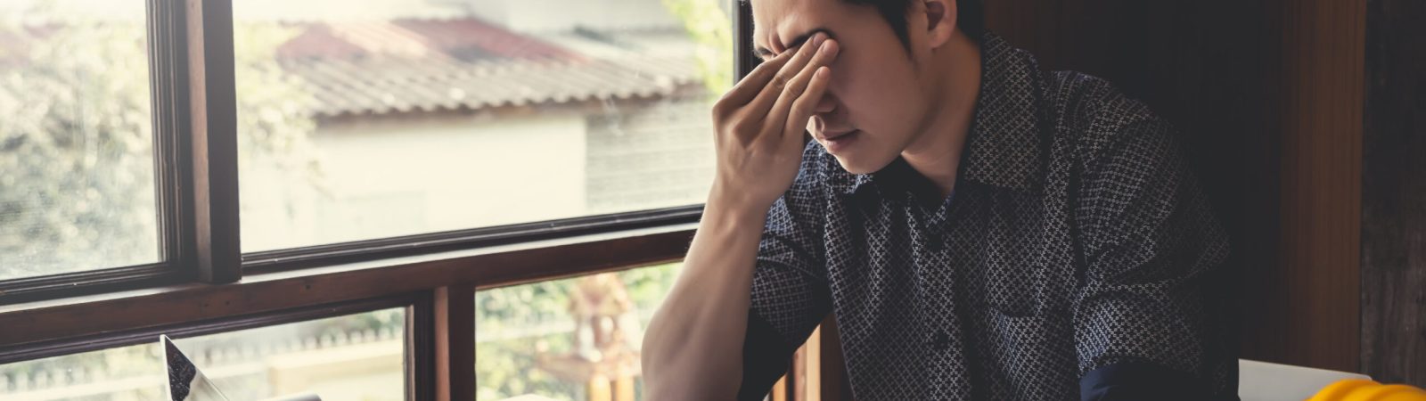 Asian male architect are feeling sick and tired or exhausted from office work.
