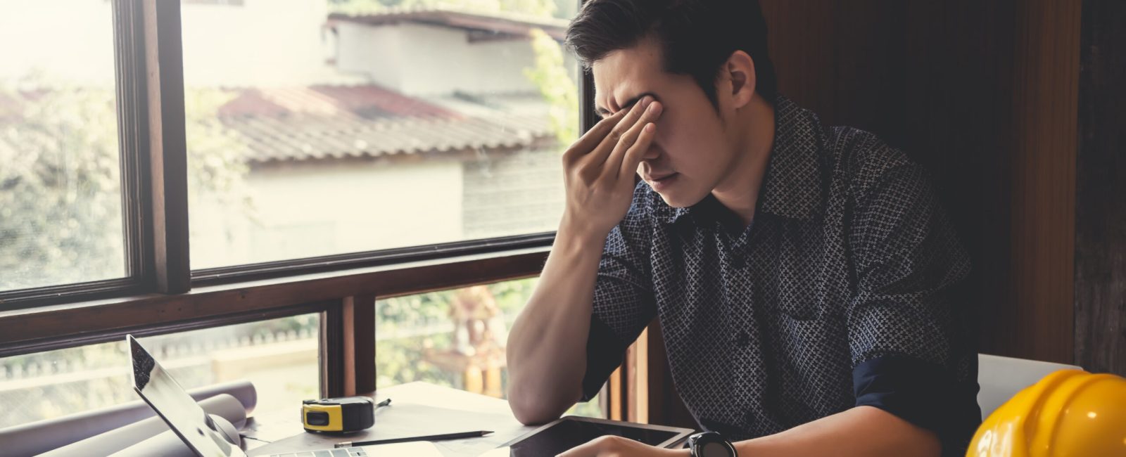 Asian male architect are feeling sick and tired or exhausted from office work.