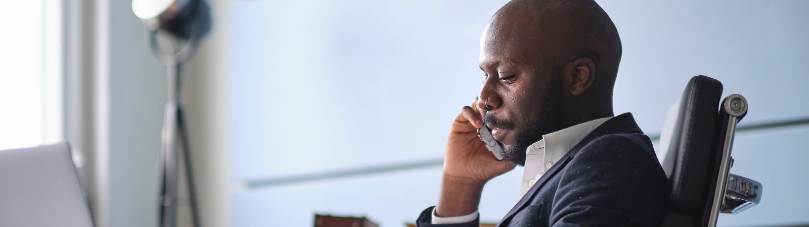 Difficult conversation with a customer. African American man talking on phone, hearing bad unexpected news