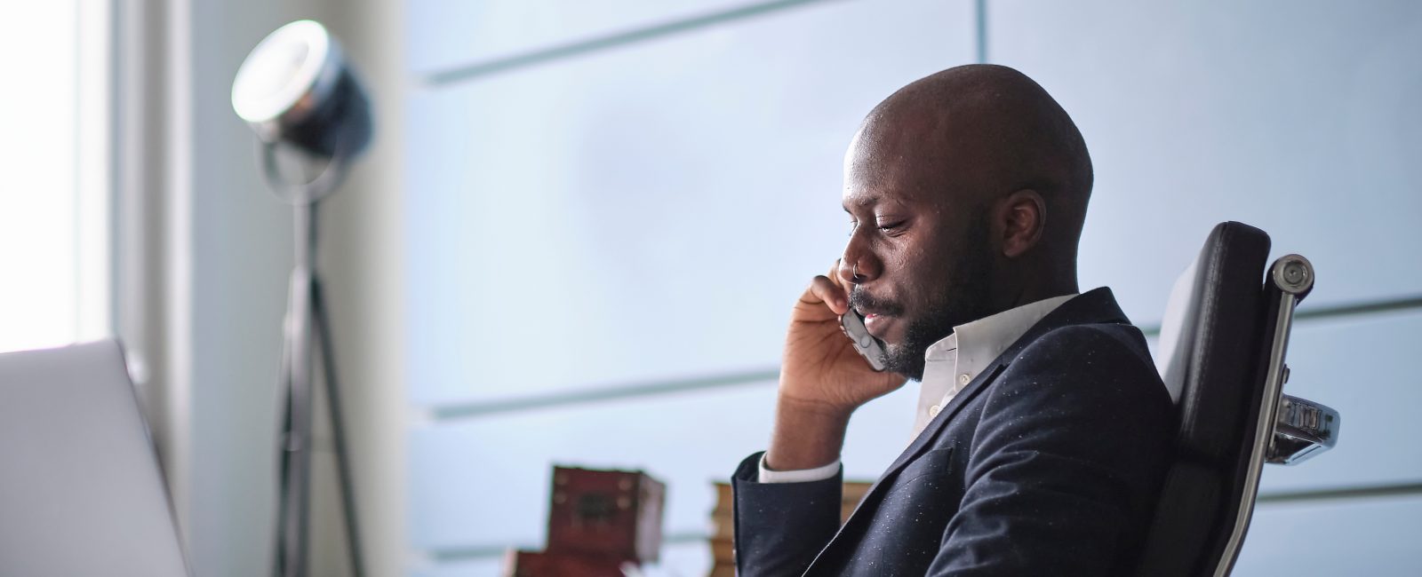Difficult conversation with a customer. African American man talking on phone, hearing bad unexpected news