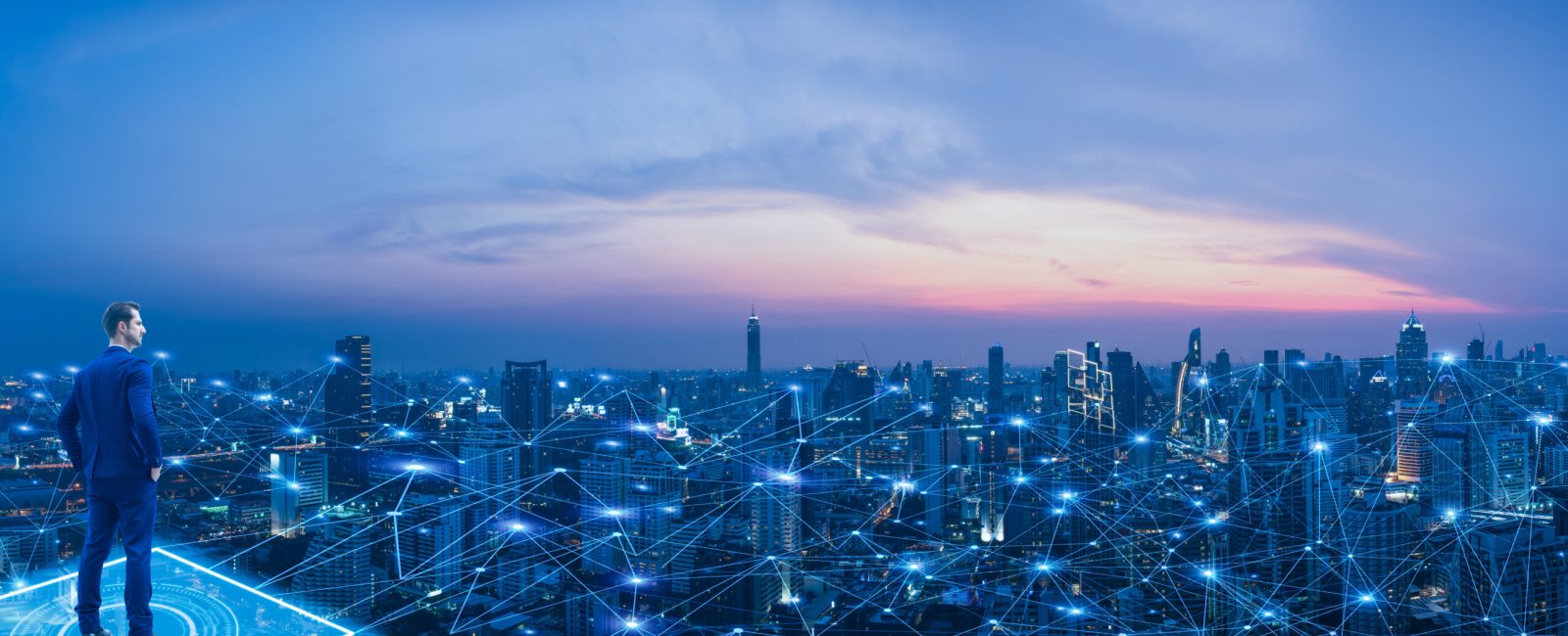 Professional business man looking on future smart city background and futuristic interface graphic at night. Business technology concept.