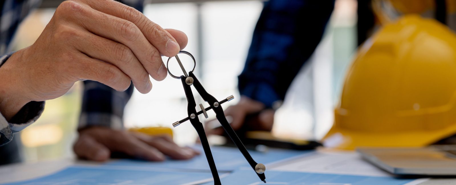 Architects use compasses to draw on building plans for editing, architect engineers design houses and interior structures and draw plans through design programs. Architect concept of building design.