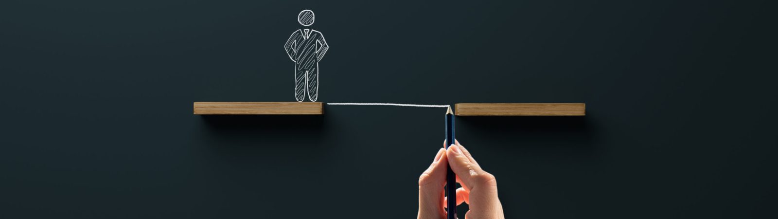 Wooden blocks and a drawn figure with a chasm, the hand draws a bridge, a passage. Concept of help in business and dealing with problems.