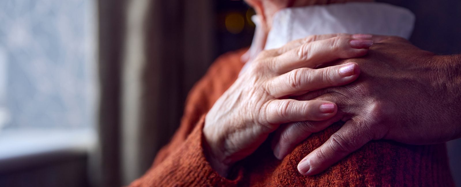 Close Up Of Senior Couple At Home With Man Putting Reassuring Hand On Woman's Shoulder