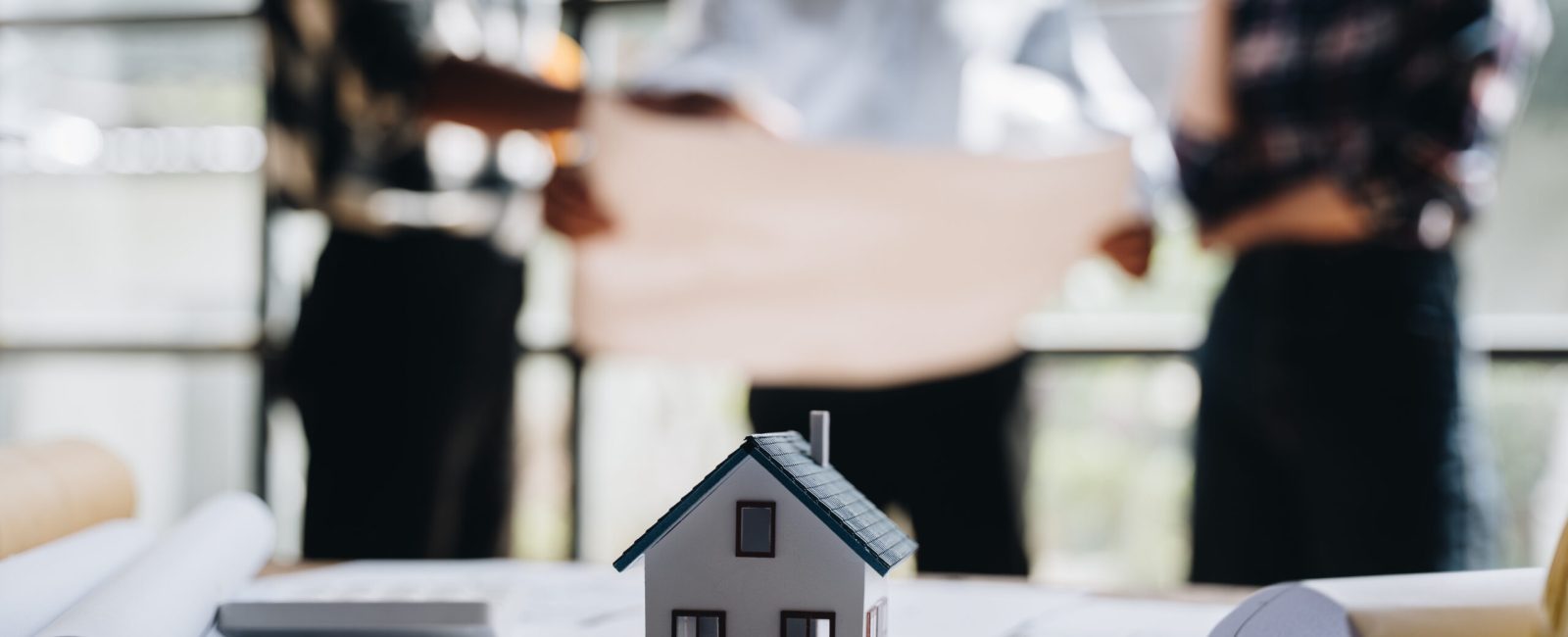 business engineering teamwork discussing a new building project with home model to successful business, selective focus at home model and hand. concept business engineering,architecture.