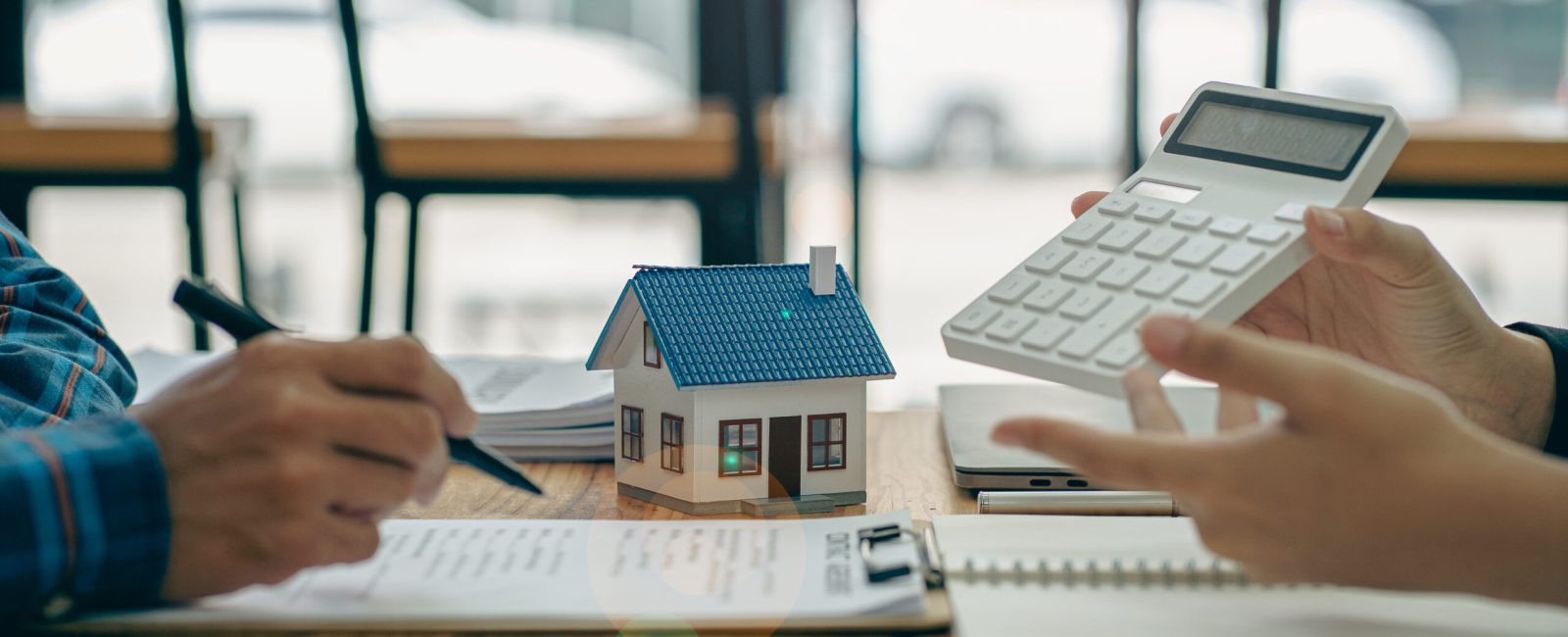 Real estate agents recommend homes and offer insurance interest rate contracts to clients in the home buying idea office.