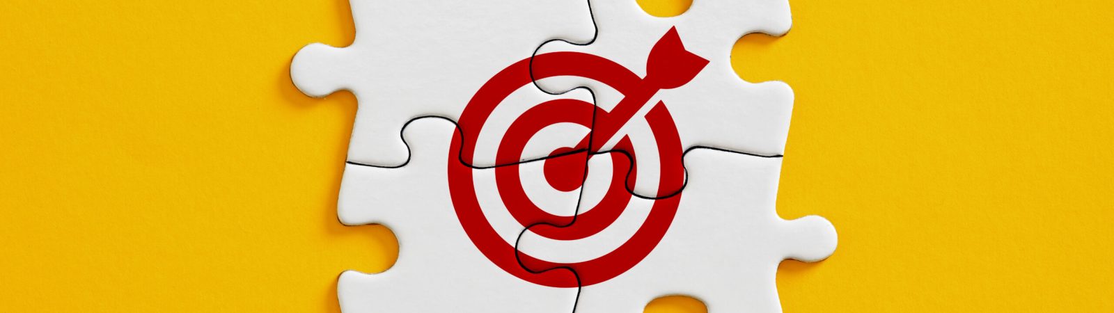 Joint effort or teamwork for achieving target goal objectives in business. Initiation and synergy to reach target. Objective, goal or target icon on connected jigsaw puzzle pieces.