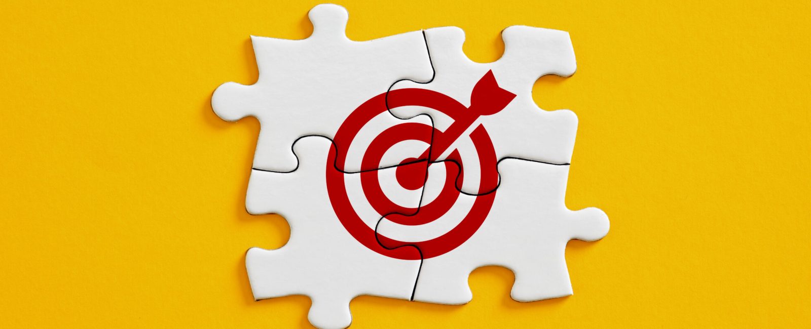 Joint effort or teamwork for achieving target goal objectives in business. Initiation and synergy to reach target. Objective, goal or target icon on connected jigsaw puzzle pieces.