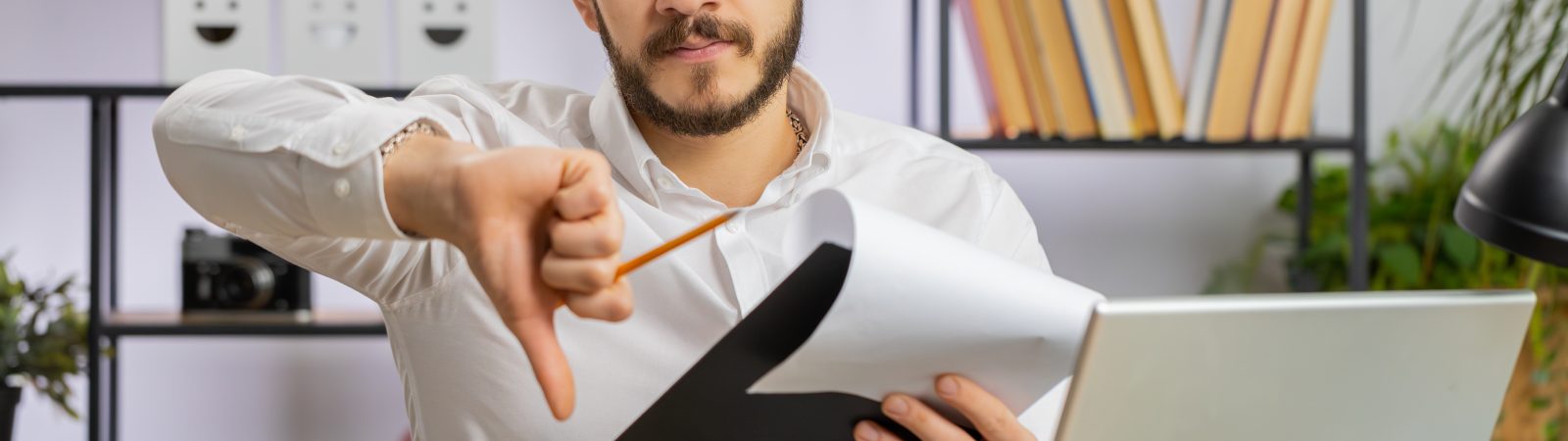 Business man reading business contract, planning project, analyzing resume, shakes finger, saying No, unsatisfied disagree, candidate with failure at office looking at camera talking, online interview