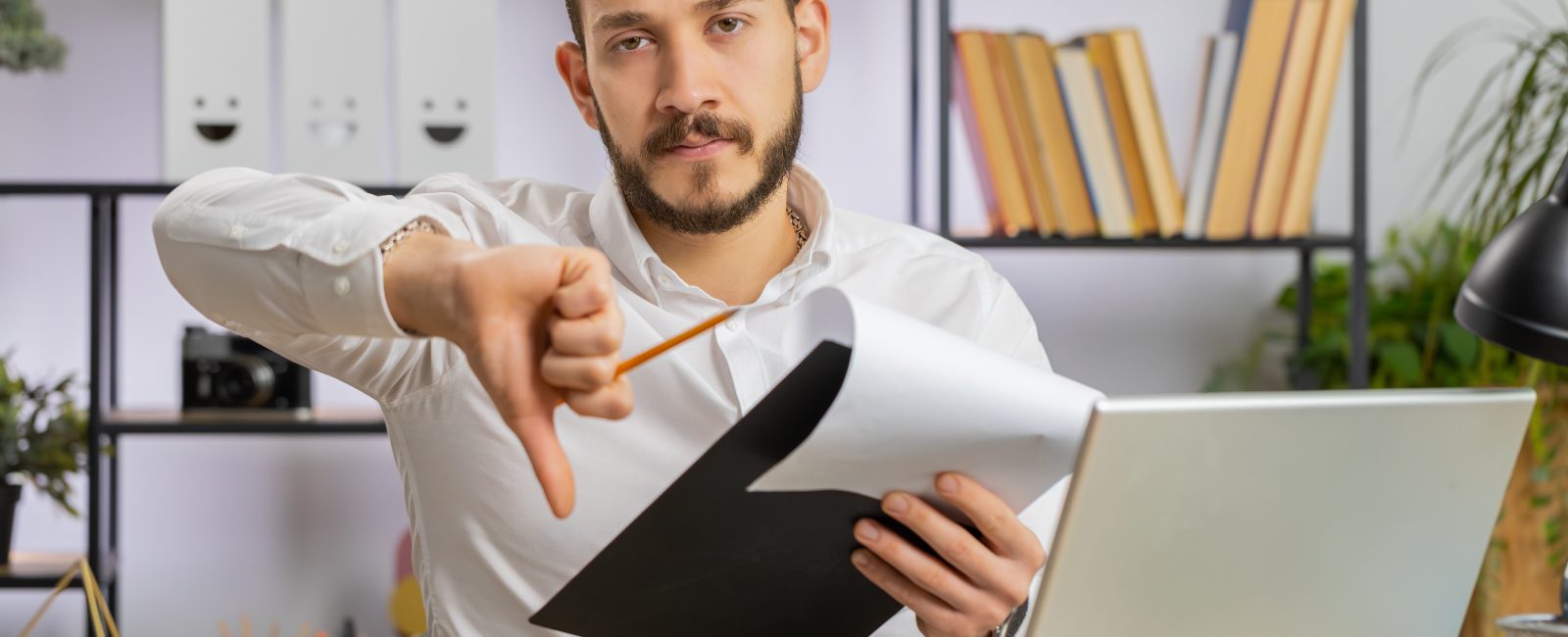 Business man reading business contract, planning project, analyzing resume, shakes finger, saying No, unsatisfied disagree, candidate with failure at office looking at camera talking, online interview