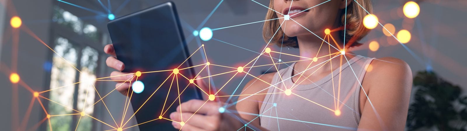 Smiling businesswoman in casual wear holding tablet device touching it at office workplace. Concept of distant work, business education, information technology. Social network abstract hologram