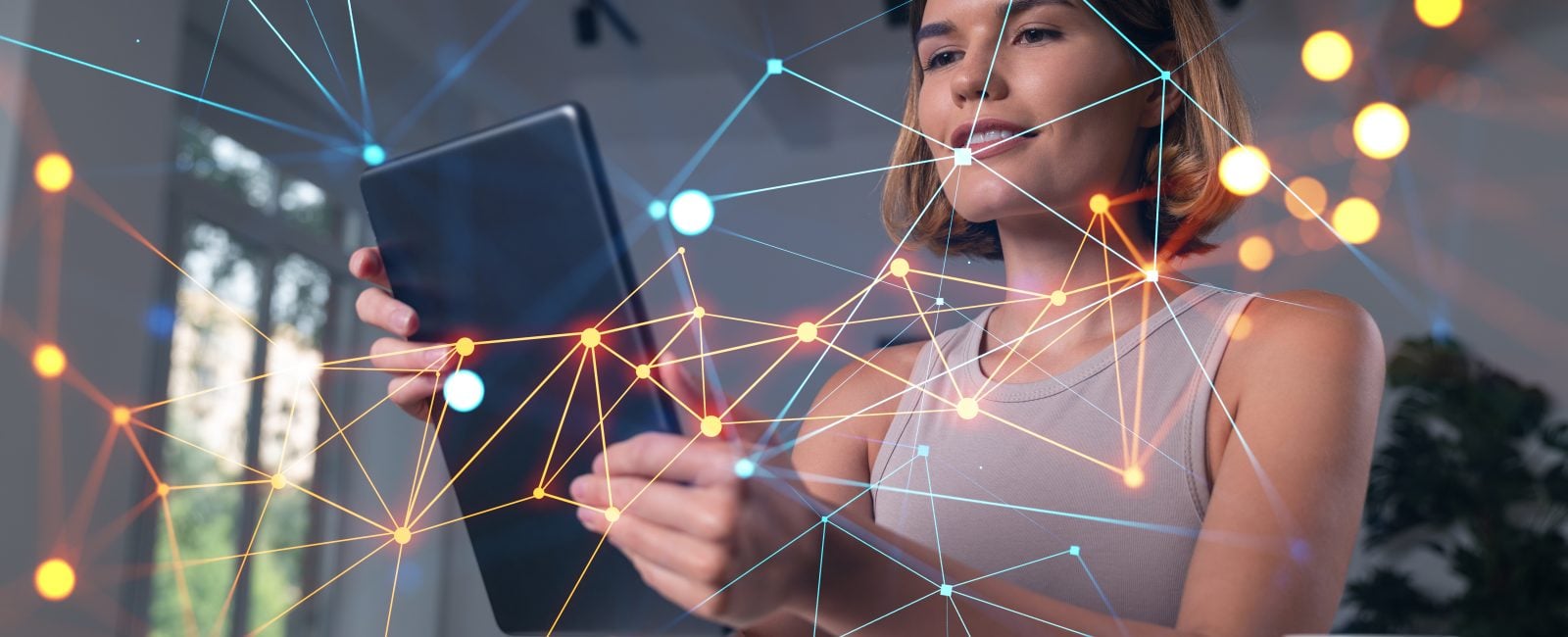 Smiling businesswoman in casual wear holding tablet device touching it at office workplace. Concept of distant work, business education, information technology. Social network abstract hologram